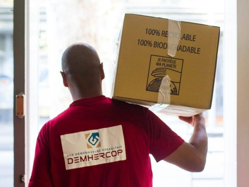 Employé de DEMHERCOP portant un carton