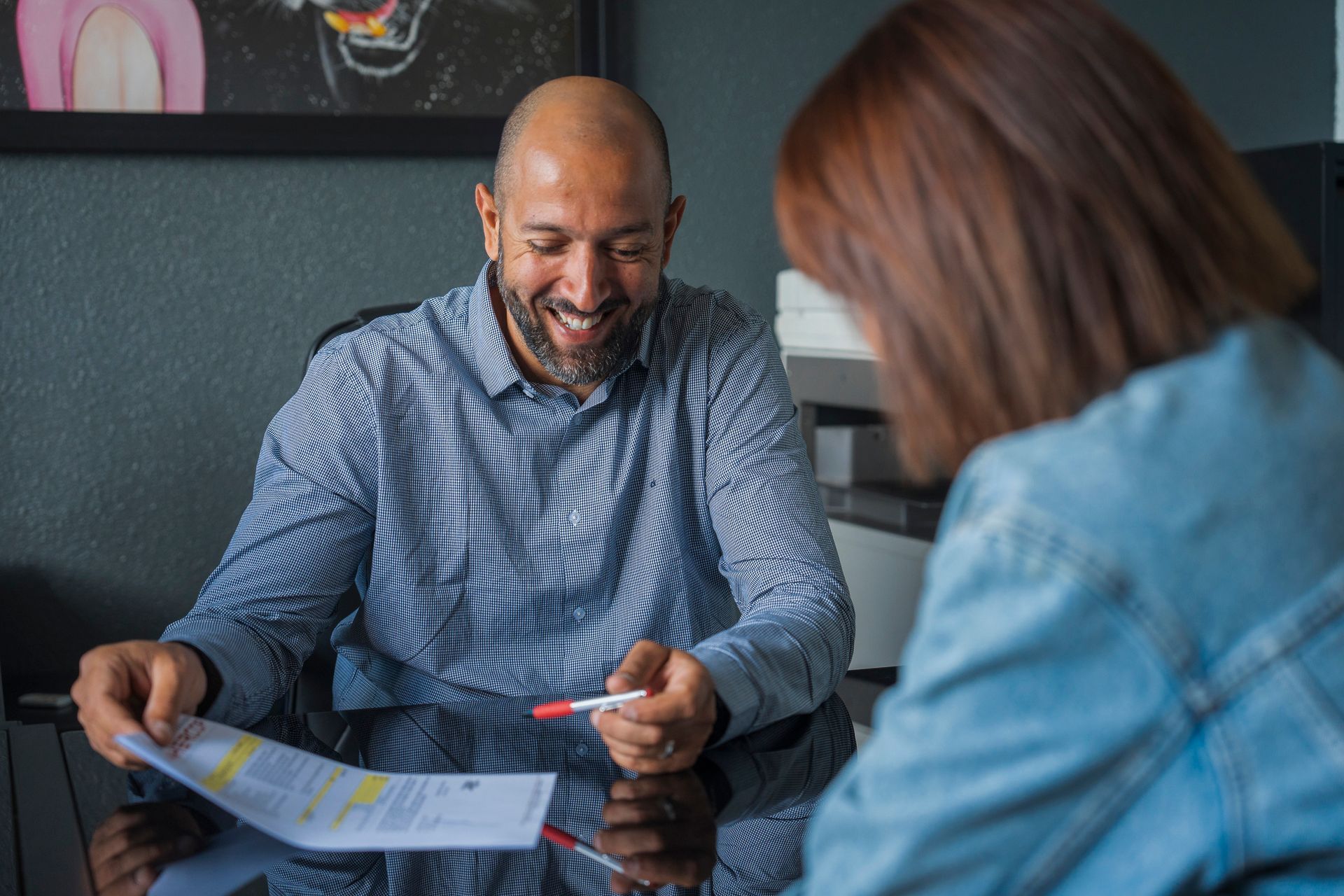 Employé de DEMHERCOP montrant un contrat de déménagement à une cliente