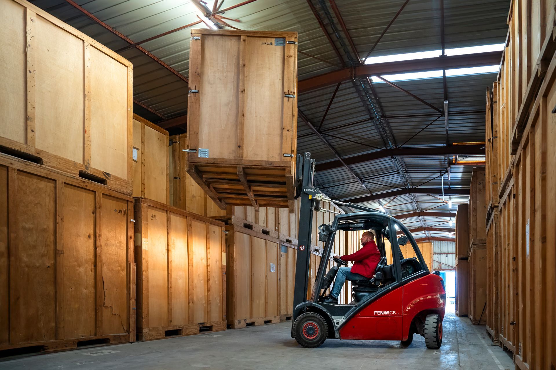 Employé de DEMHERCOP utilisant un chariot élévateur pour déposer un box de stockage