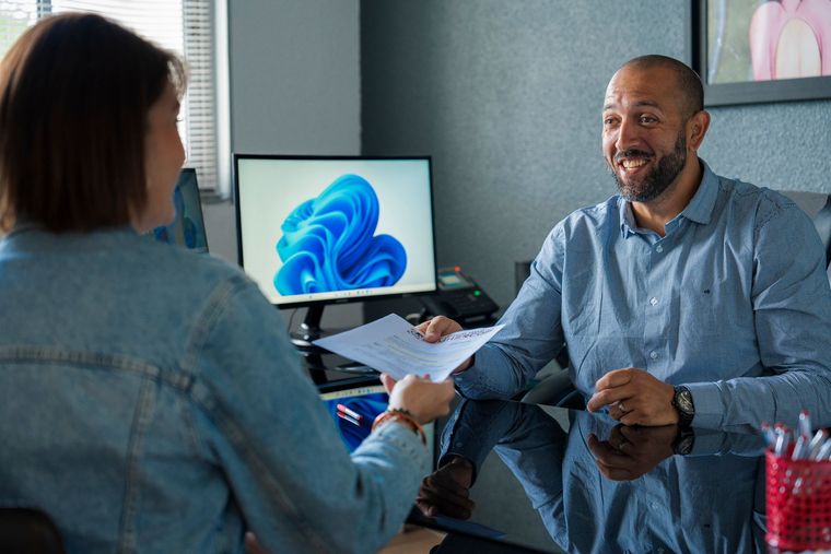 Employé de DEMHERCOP à son bureau avec une femme