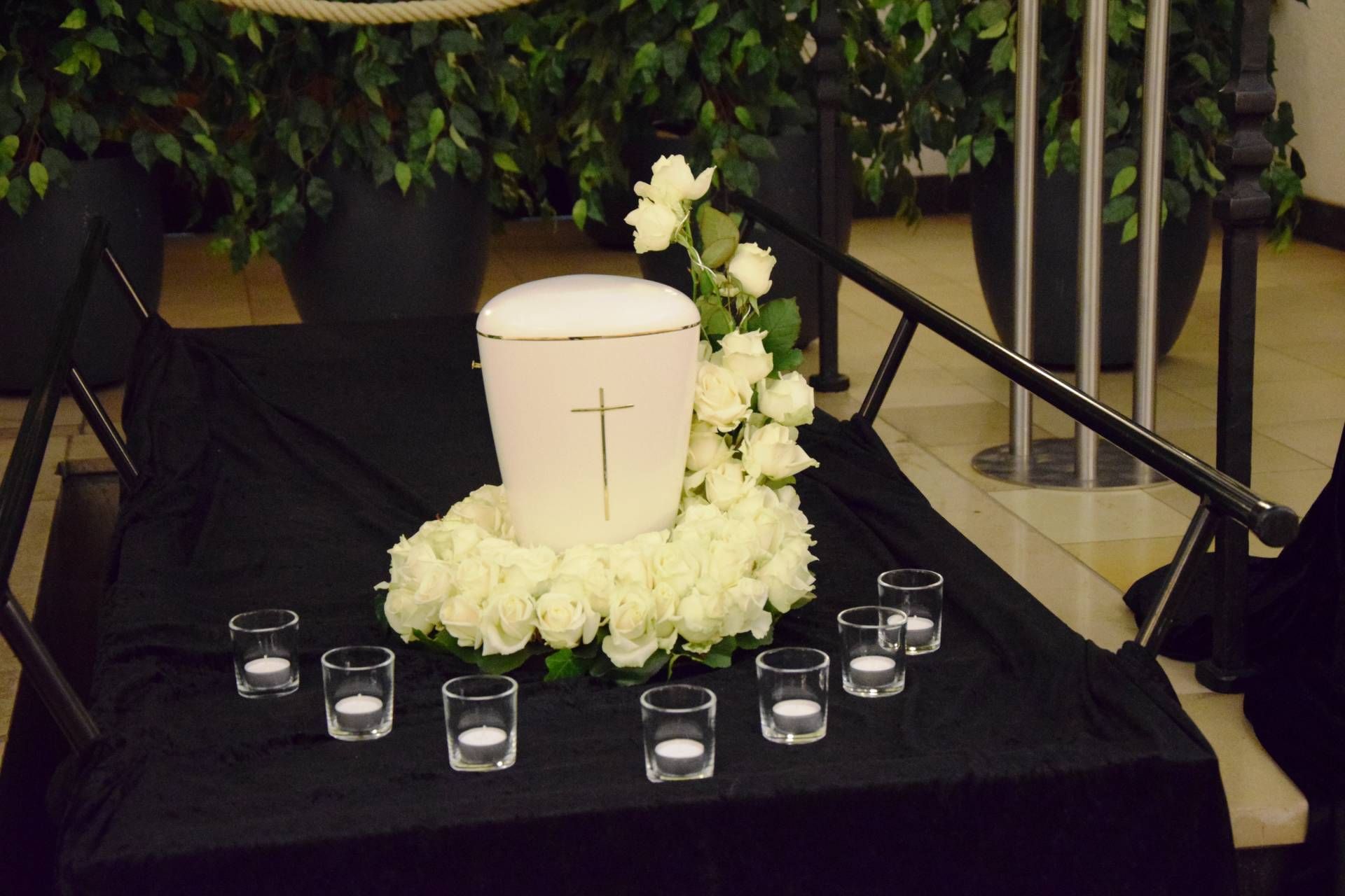 weiße Urne mit Blumenkranz