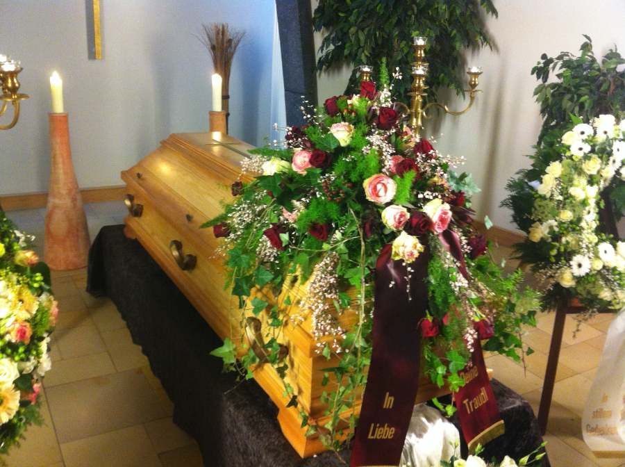 Sarg mit Blumendekoration in rosa und weiß