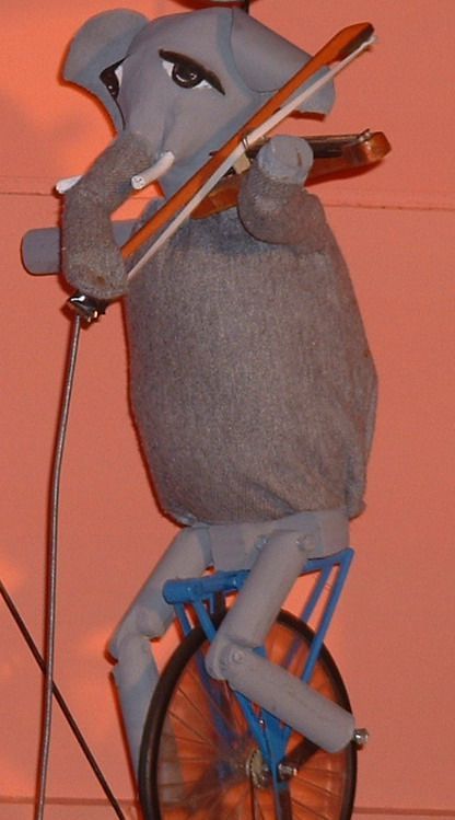 Marionnette d'éléphant jouant du violon à côté d'un microphone