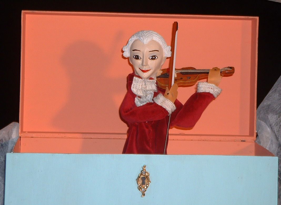 Petite figurine en vêtement rouge avec un violon