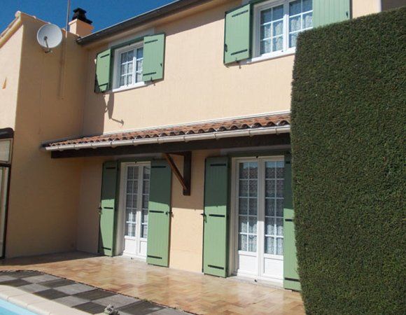 Rénovation de façade avec des volets verts