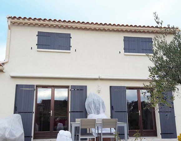 Rénovation de façade avec des volets gris foncé