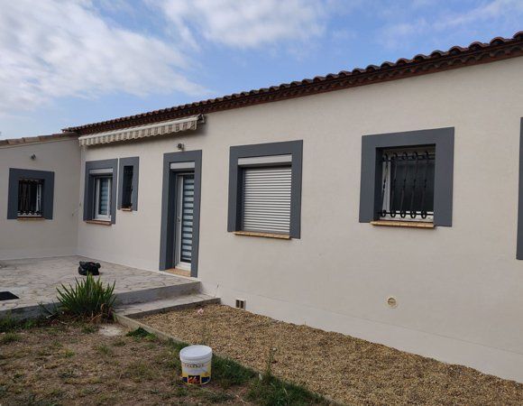 Maison avec un store au dessus de la porte d'entrée