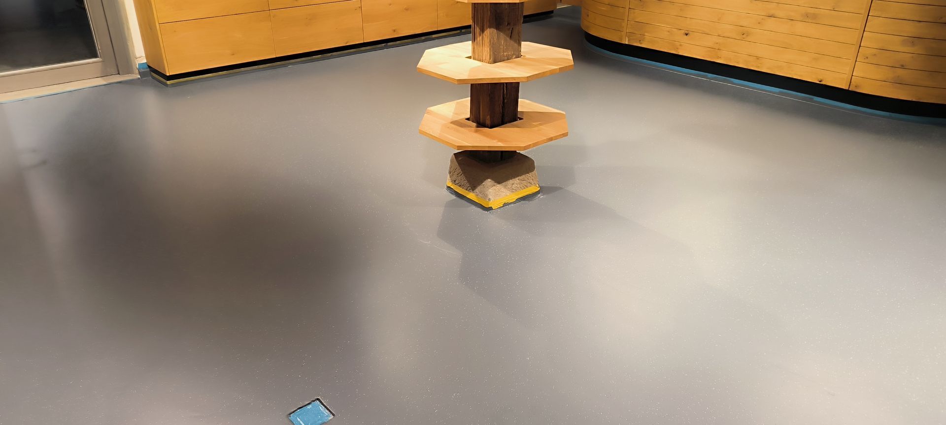 Ein grüner Müllcontainer voller Müllsäcke und Holz.