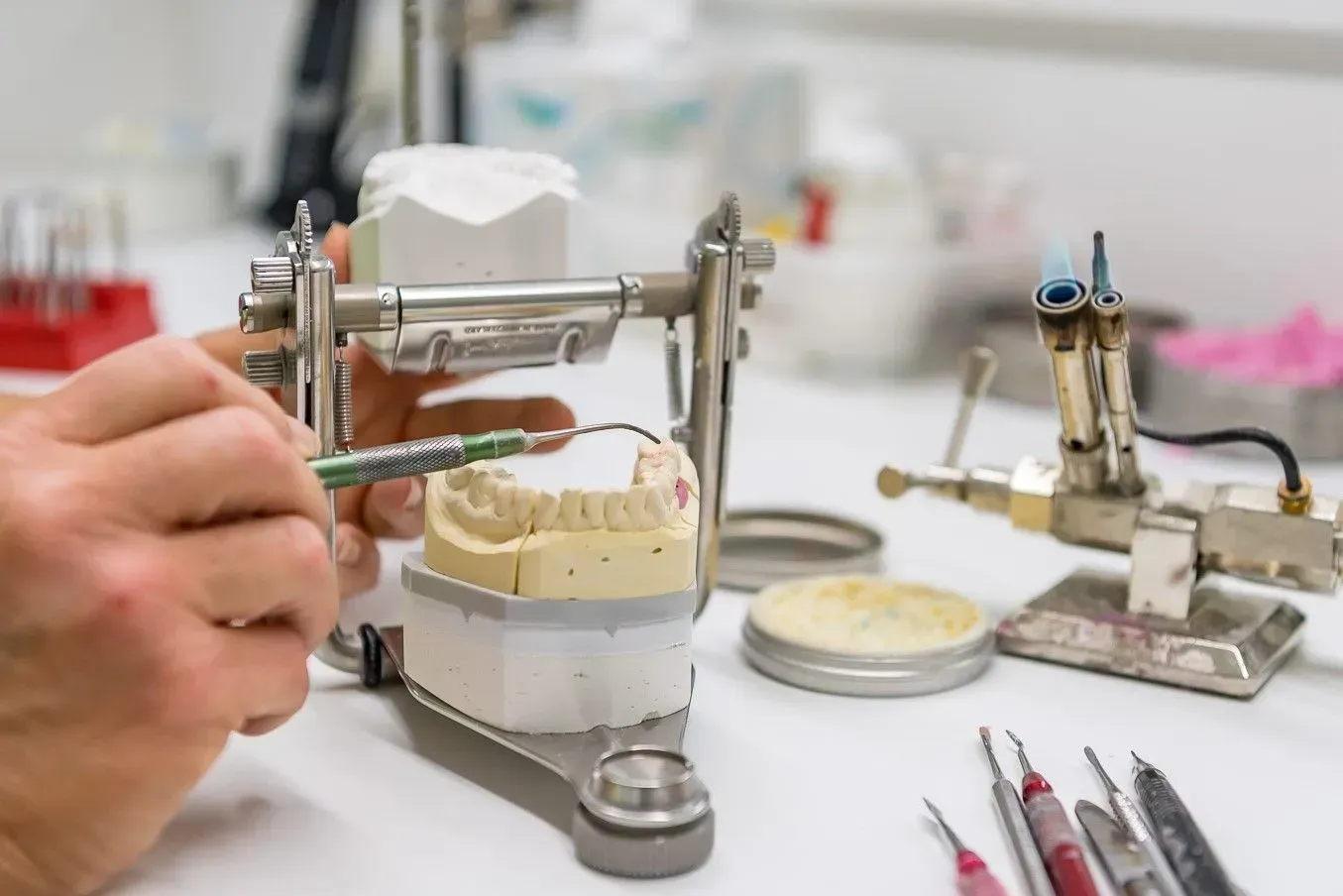 Ein Zahnarzt arbeitet an einem Modell der Zähne einer Person. Dentaltechnik Claudia Meier