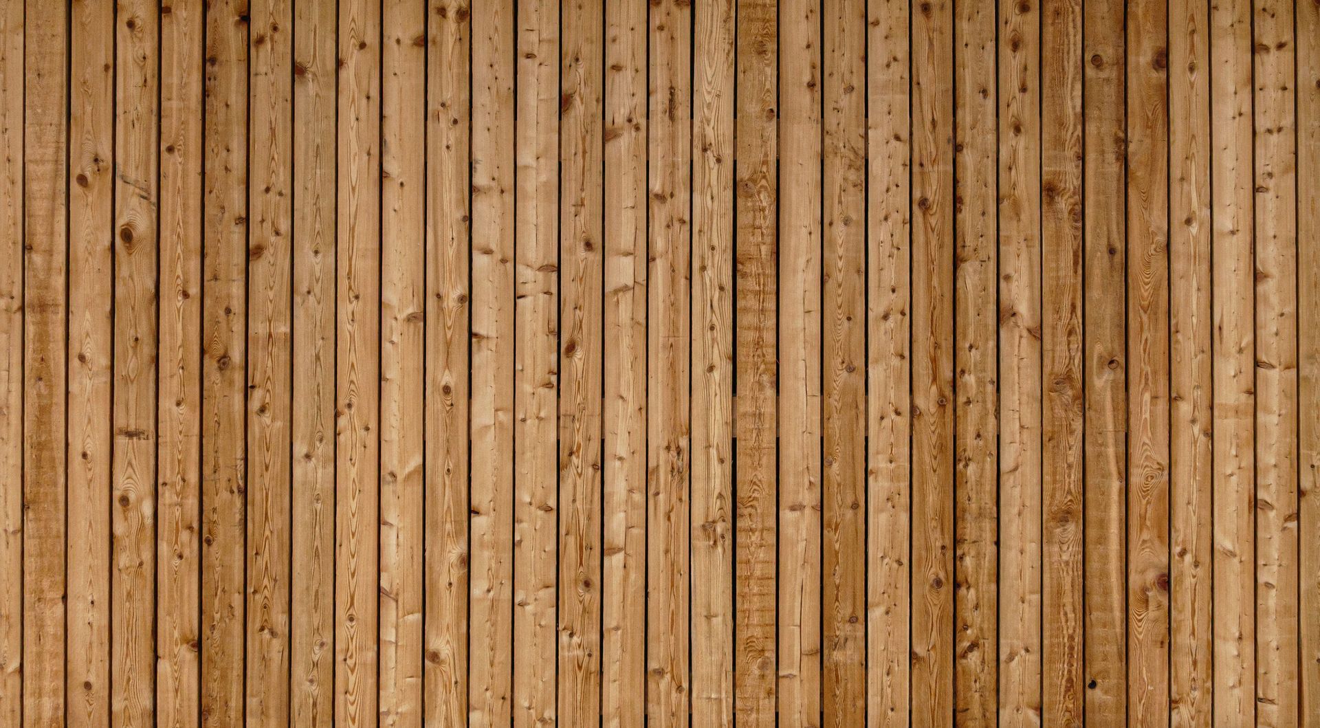 Planches de bois brun clair avec grain, nœuds et textures visibles, disposées verticalement.