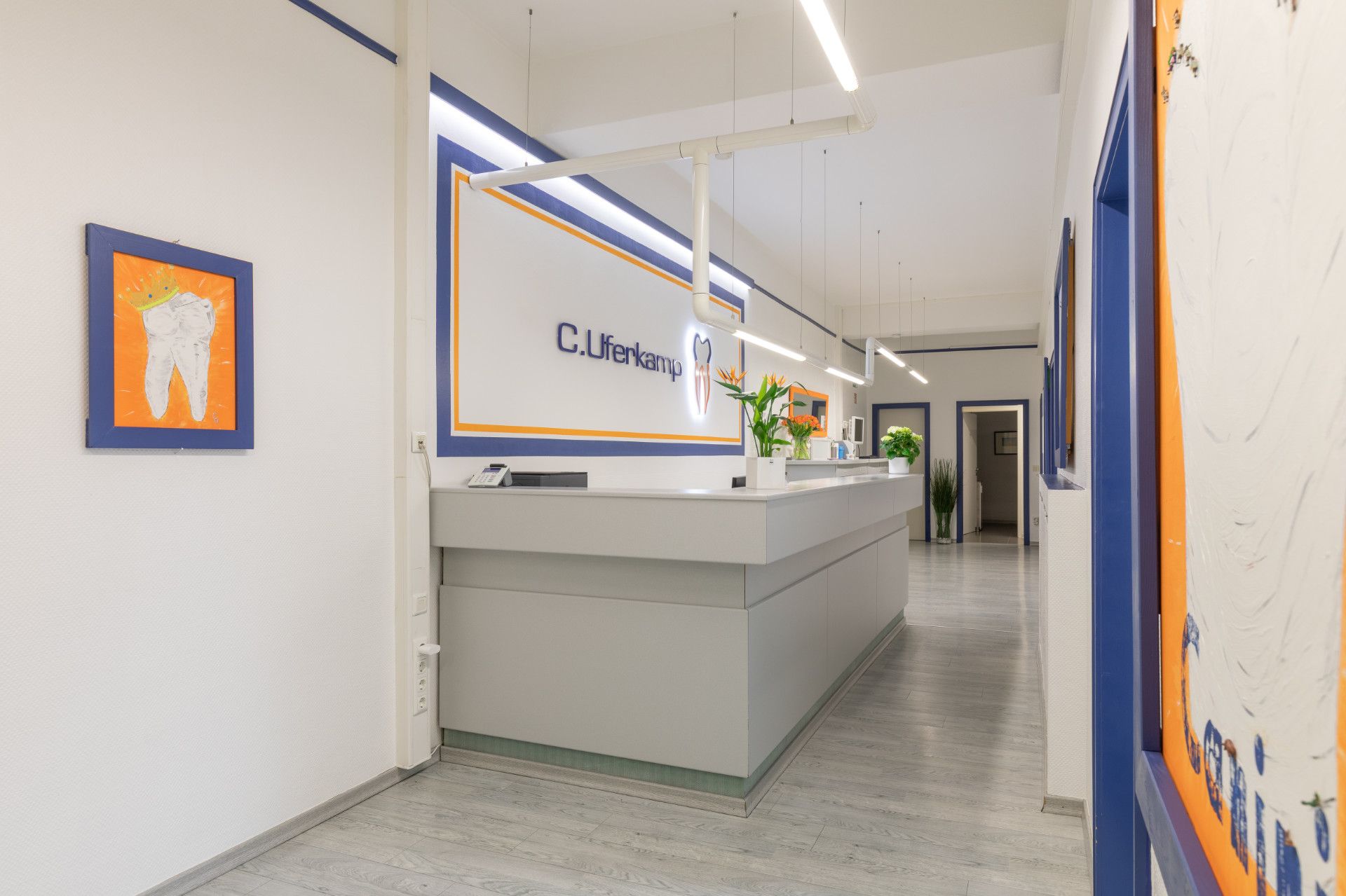 Eine Zahnarztpraxis mit einem Empfangstresen und einem Bild eines Zahns an der Wand.