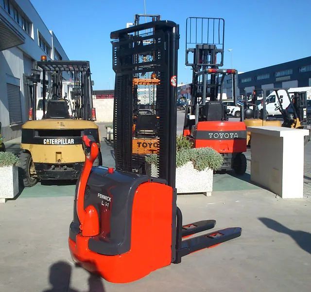 Una carretilla elevadora Toyota está estacionada junto a una carretilla elevadora Caterpillar