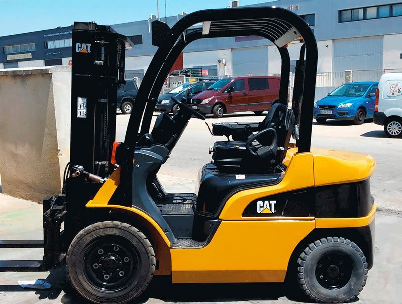 Una carretilla elevadora de gato amarilla está estacionada en un estacionamiento