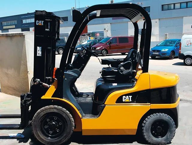 Una carretilla elevadora de gato amarilla está estacionada en un estacionamiento