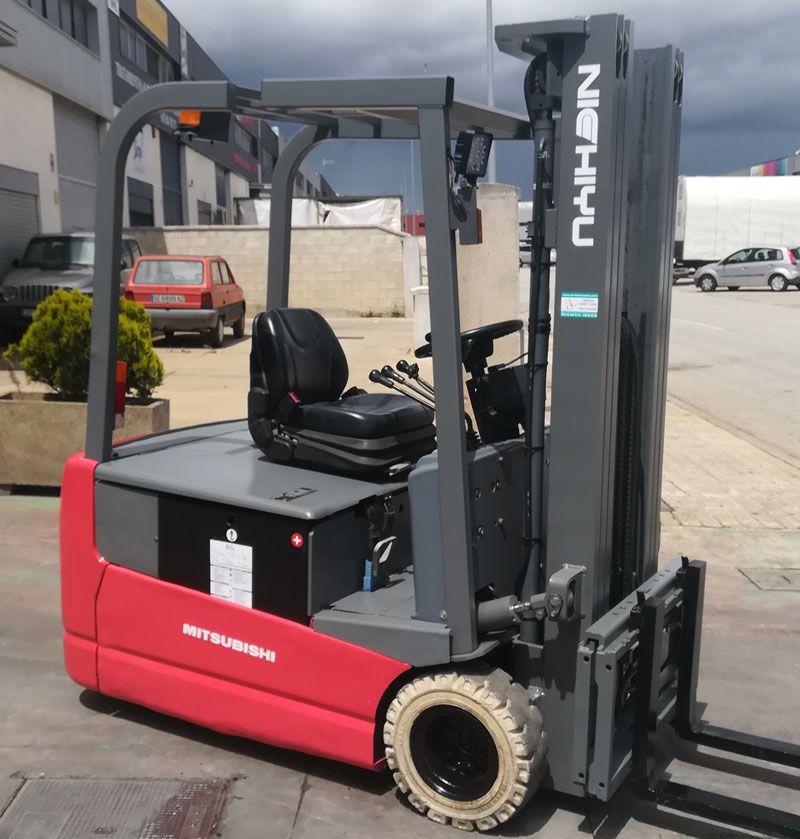 Una carretilla elevadora roja y gris está estacionada en un estacionamiento