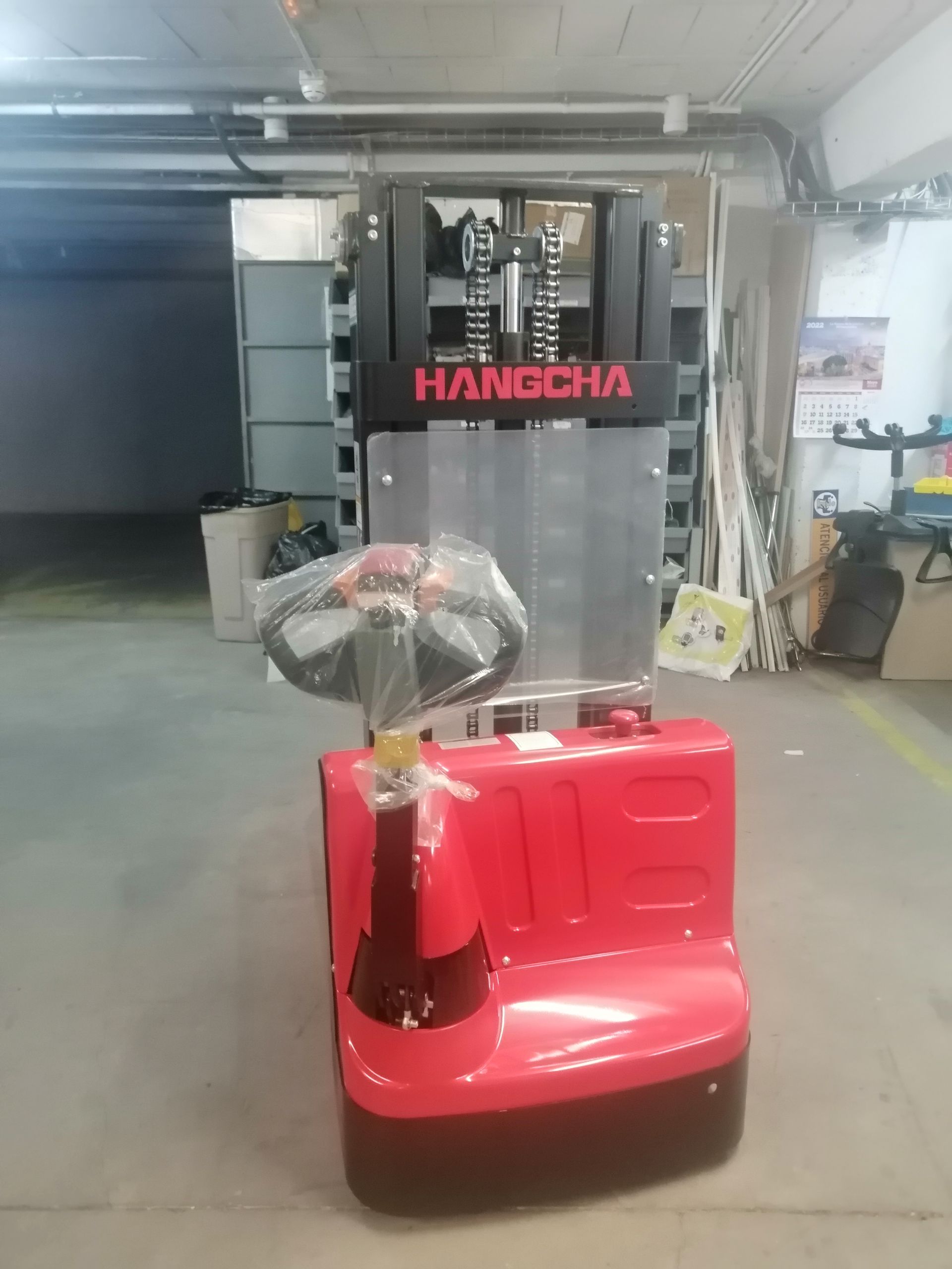 Una carretilla elevadora roja está parada en un garaje.