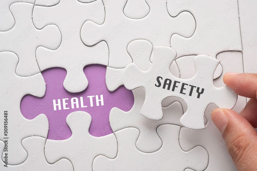 Ein Arzt legt einer Person nach einer Impfung einen Verband an den Arm. Die Person lächelt.