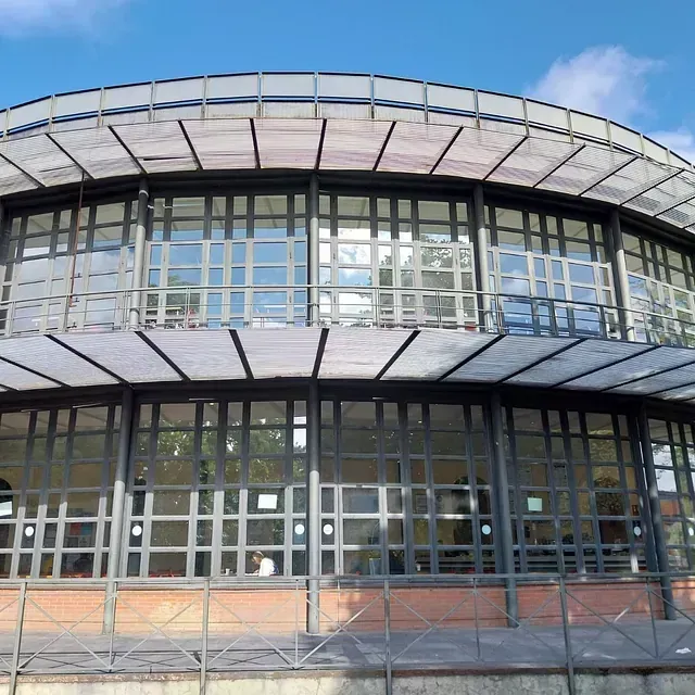 Un edificio grande con muchas ventanas y un techo transparente.