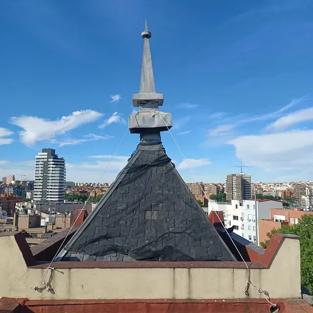 Una azotea con un techo en forma de pirámide y una ciudad al fondo.