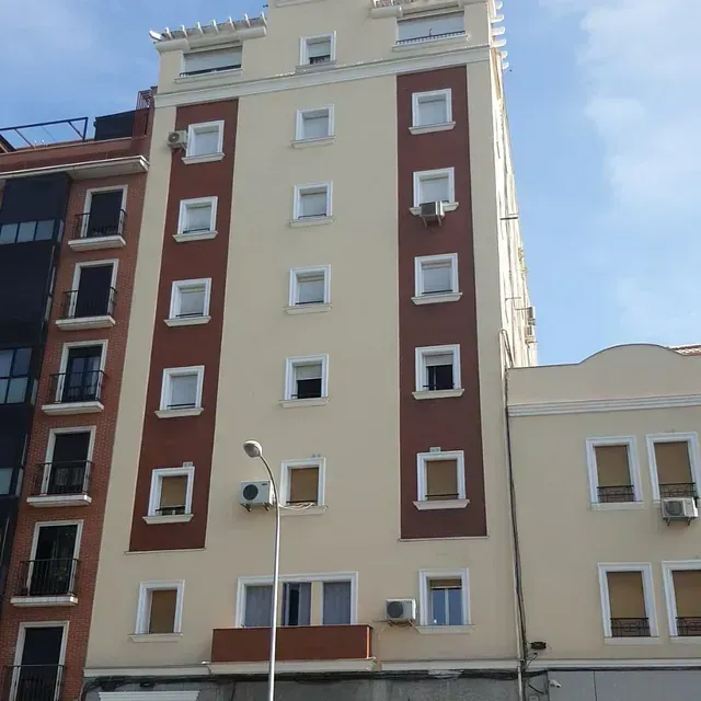 Un edificio alto con muchas ventanas y balcones.
