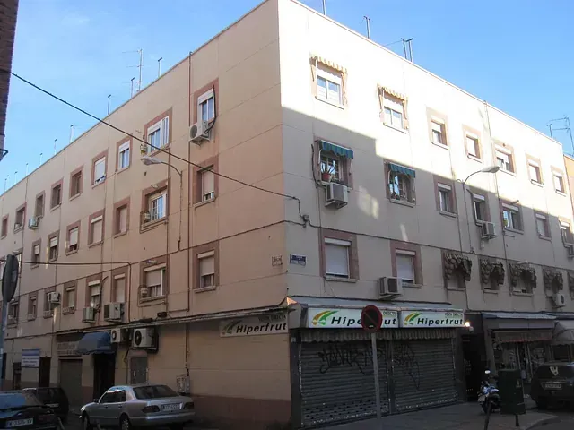 Un gran edificio con una señal de stop delante.