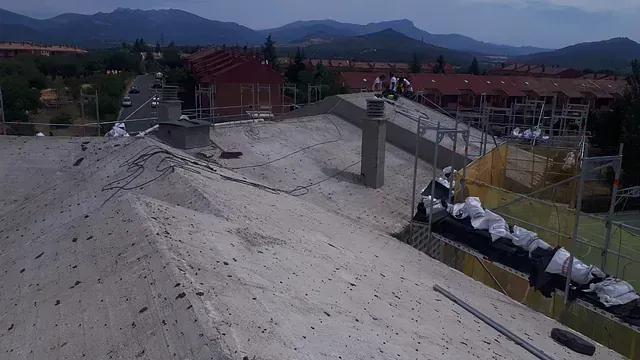 Una vista aérea de un edificio en construcción con montañas al fondo.
