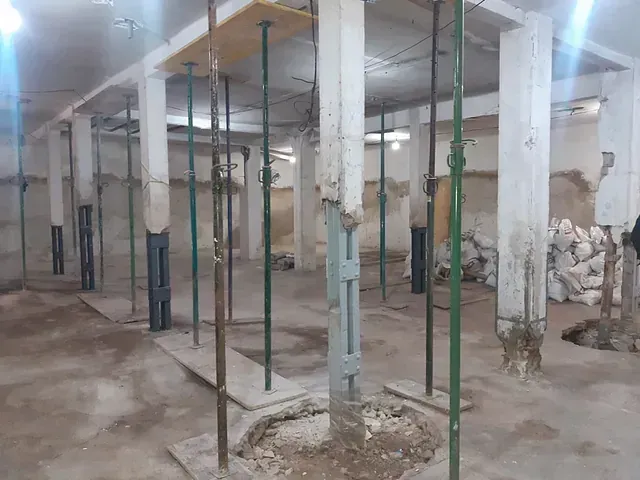 Un almacén con muchos postes verdes en su interior.