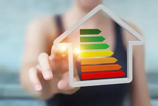 Una mujer sostiene una casa con una clasificación de eficiencia energética en su interior.