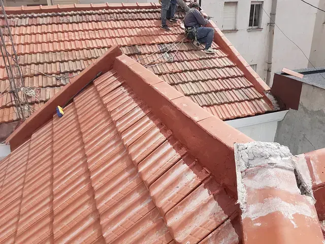 Un hombre está trabajando en el tejado de un edificio.
