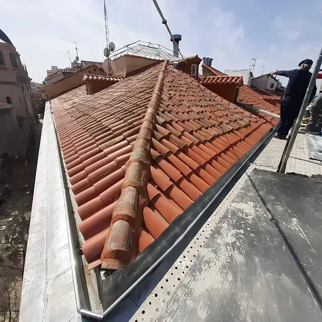 Un hombre está parado en el tejado de un edificio.