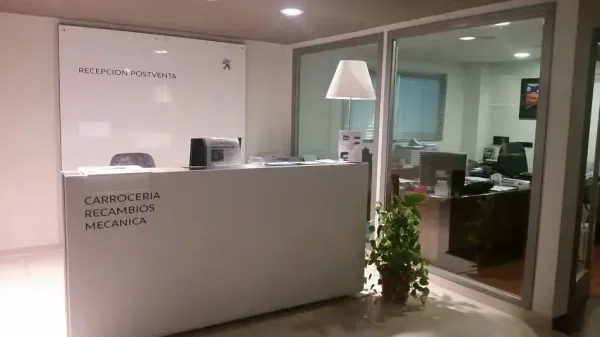 Un mostrador blanco en una habitación con una planta delante de él.