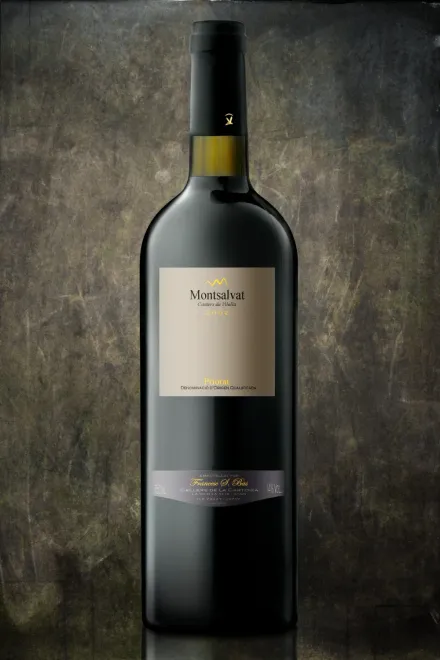 Una botella de vino tinto con etiqueta dorada, centrada sobre un fondo oscuro y texturizado.