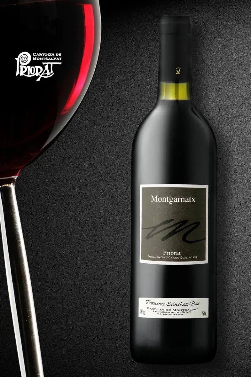 Una botella de vino tinto Muga junto a una copa de vino tinto parcialmente visible sobre un fondo oscuro y texturizado.