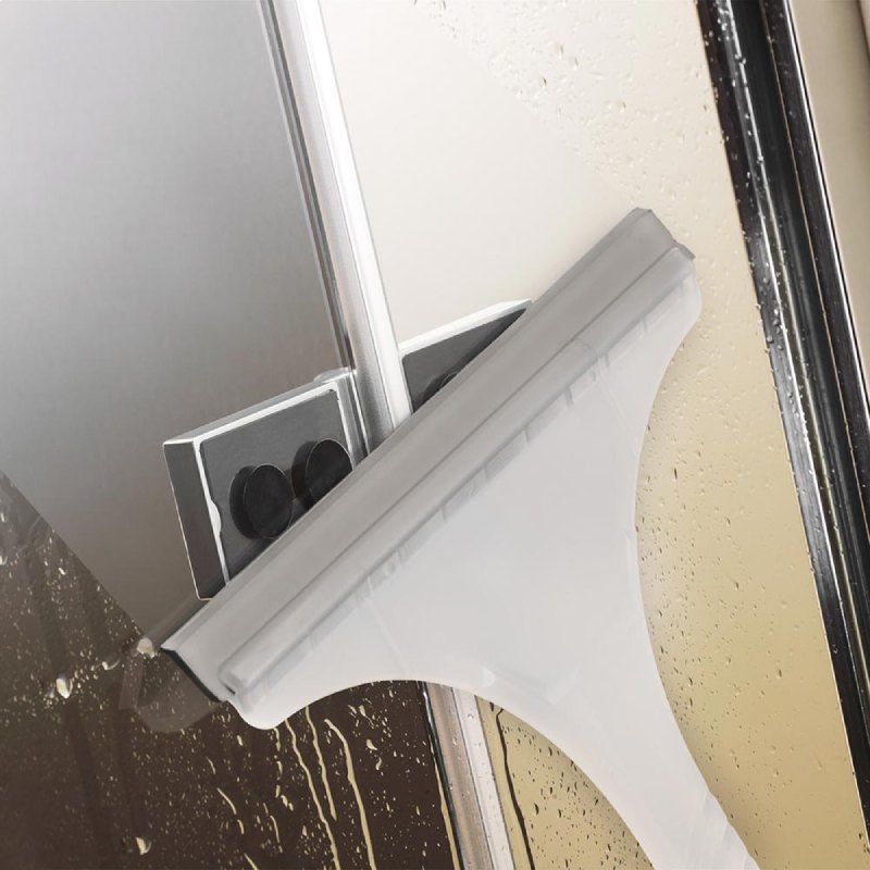 Ein Abzieher reinigt eine Duschtür aus Glas mit magnetischer Halterung.