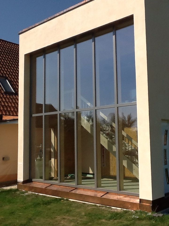 Bauarbeiter in der Nähe von Fenstern an einem Gebäude mit gelber Isolierung.