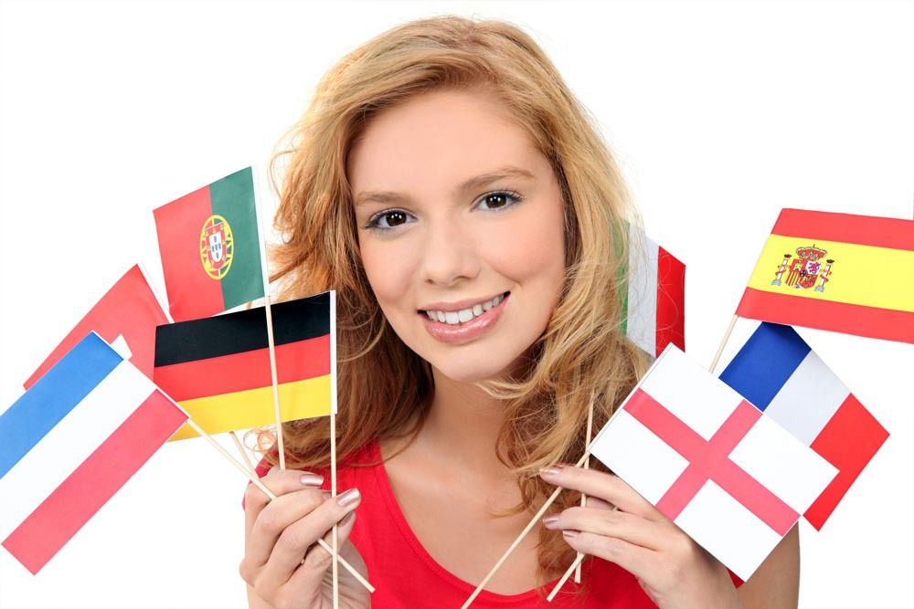 Una mujer con una camisa roja sostiene banderas de diferentes países.