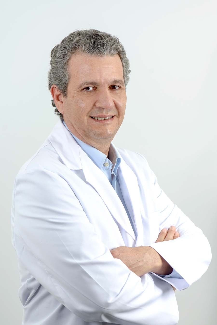 Un hombre con una bata blanca de laboratorio y los brazos cruzados.