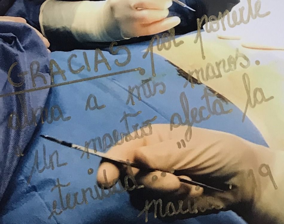 Una persona que sostiene un par de tijeras delante de un cartel que dice gracias.