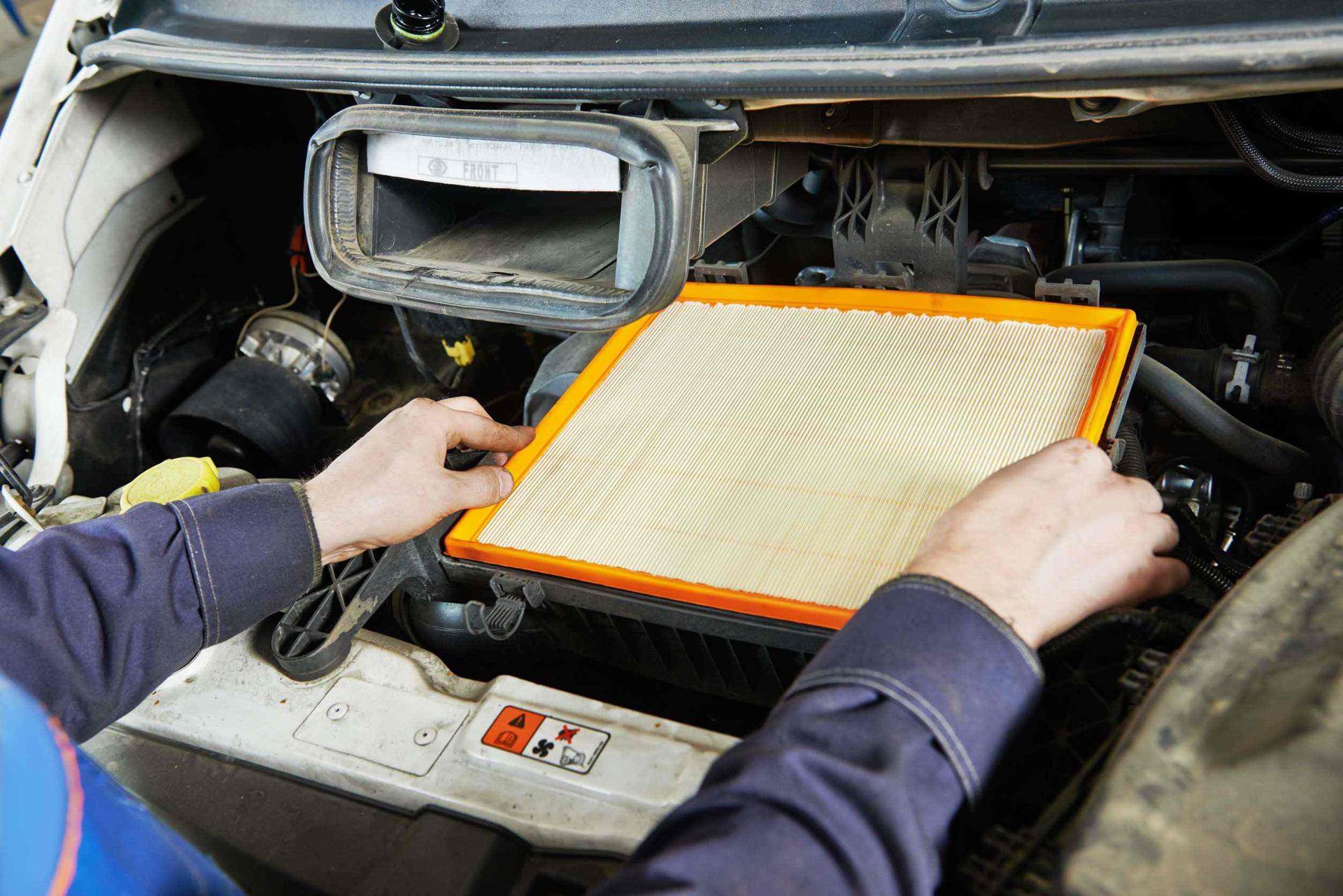 Una persona está cambiando un filtro de aire en un automóvil.
