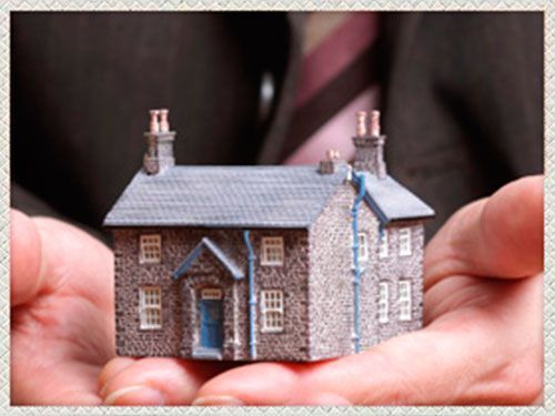Abogado Jorge Rico sosteniendo casa en miniatura