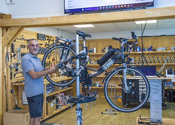 Professionnel travaillant sur la transformation d'un vélo classique en vélo électrique