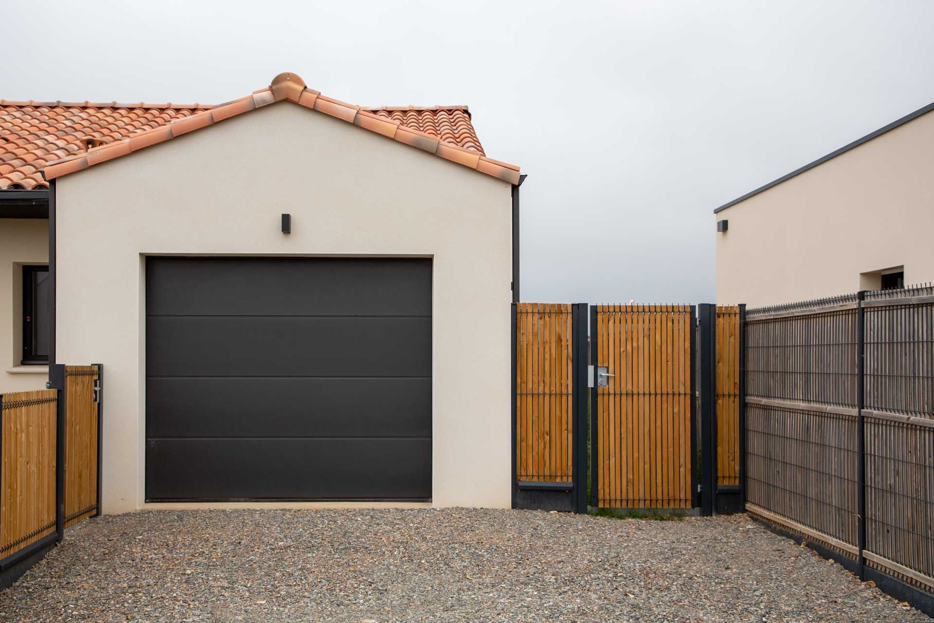 Porte de garage sectionnelle dans une cour gravillonnée