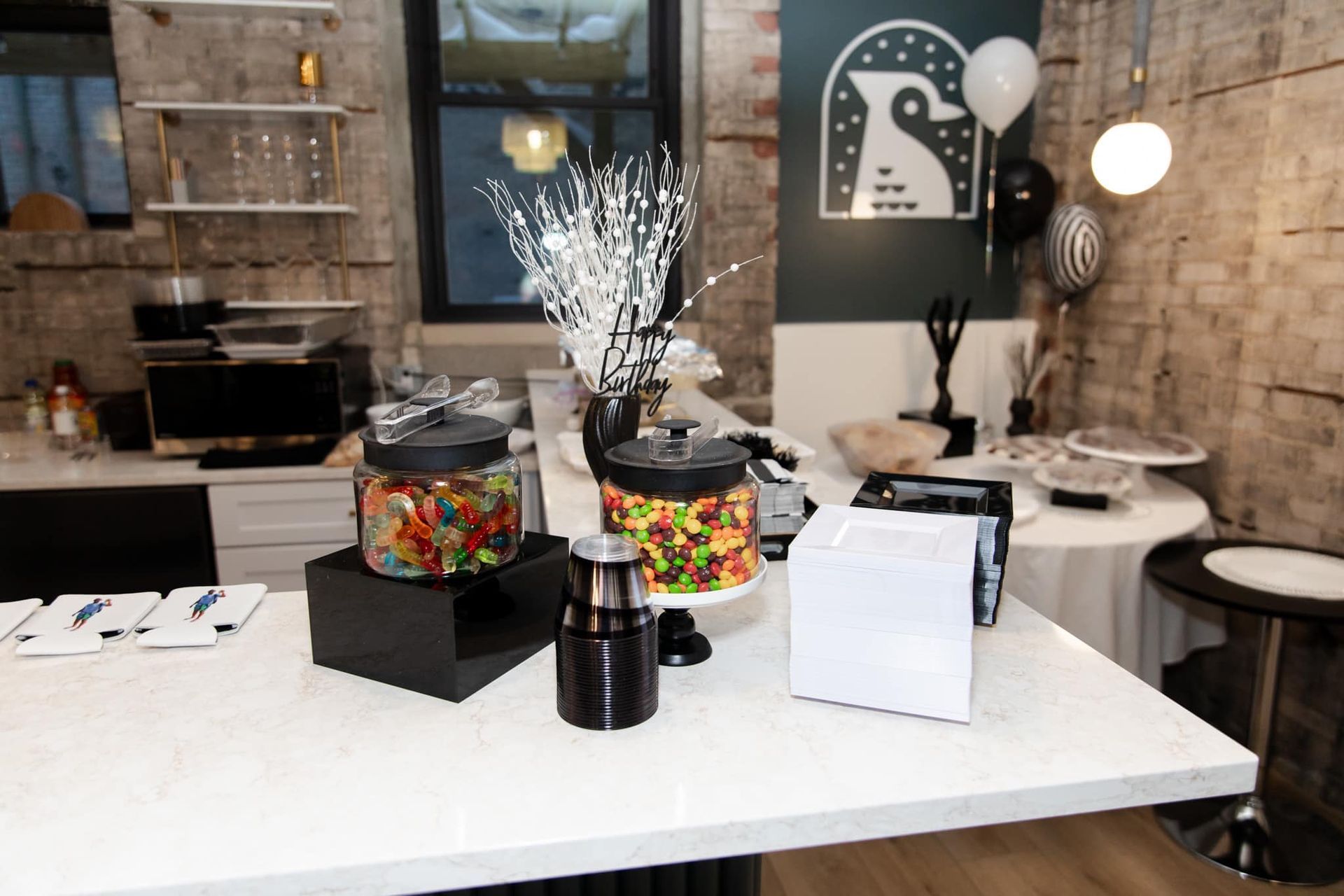 A table with jars of candy and a cake on it.