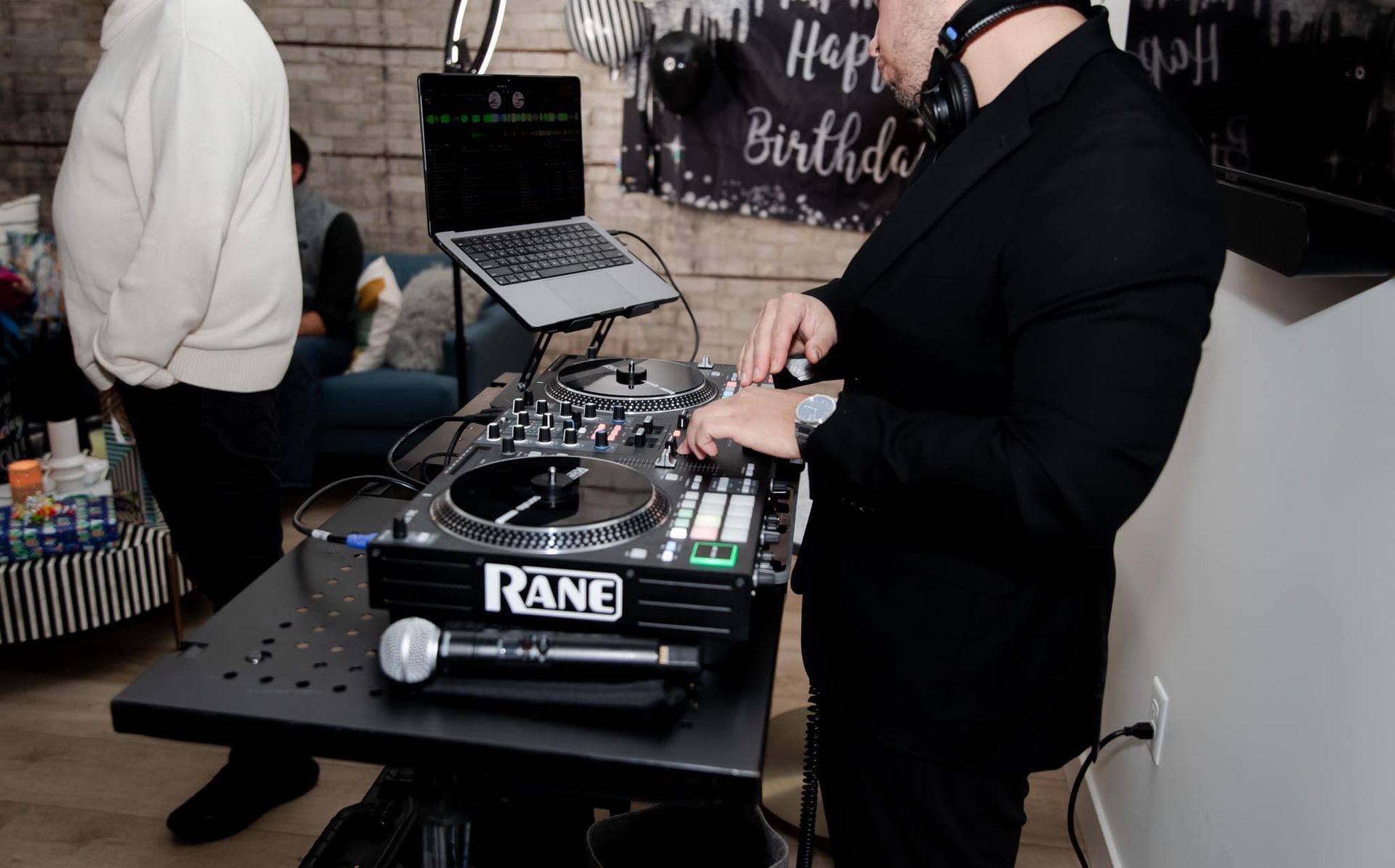 A man is playing music on a turntable in a living room.