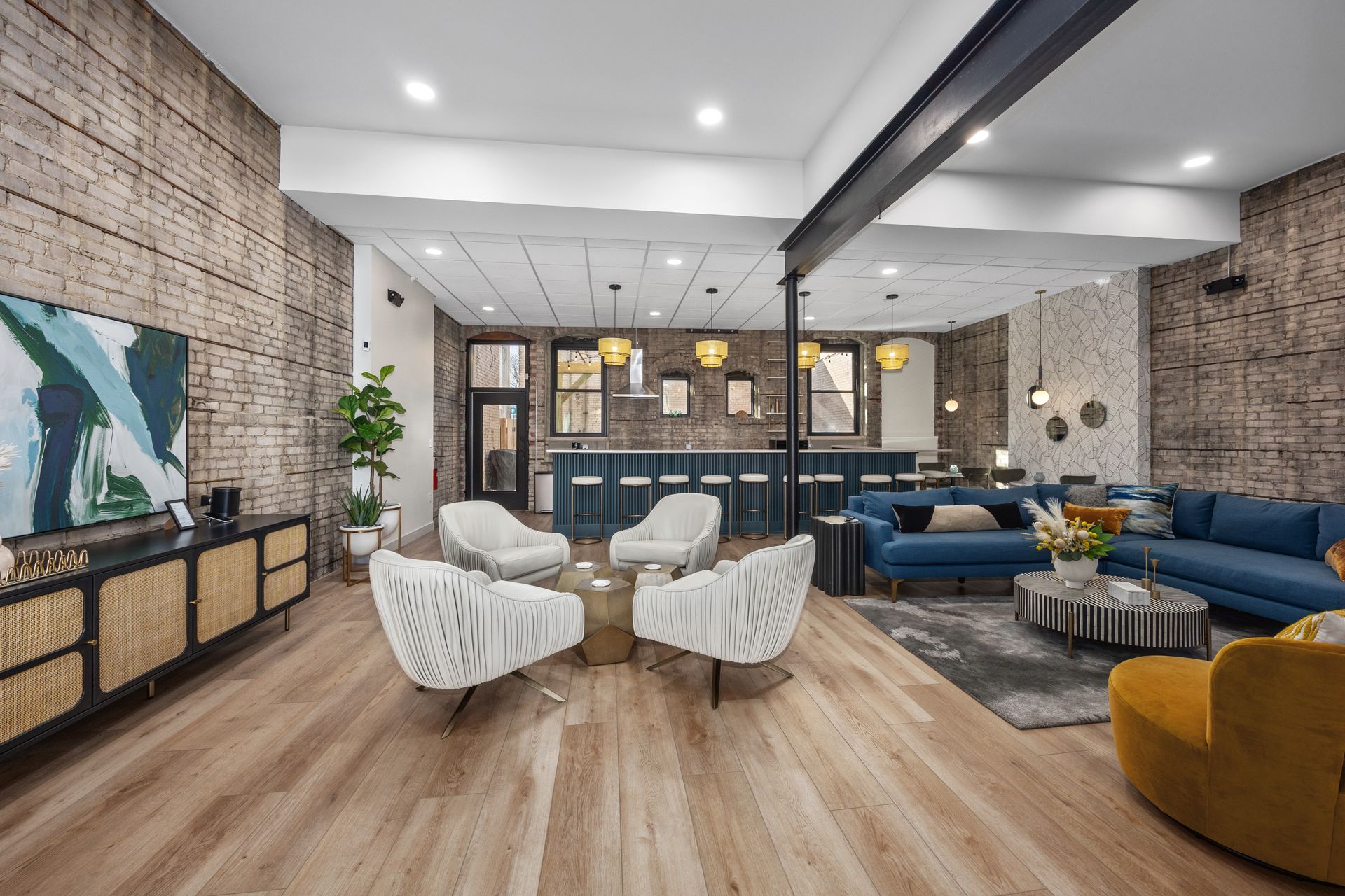 A living room with a couch , chairs , tables and a television.