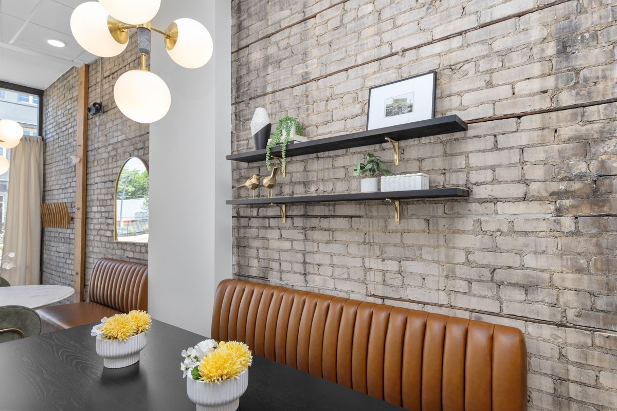 There is a brick wall behind the table and a bench.