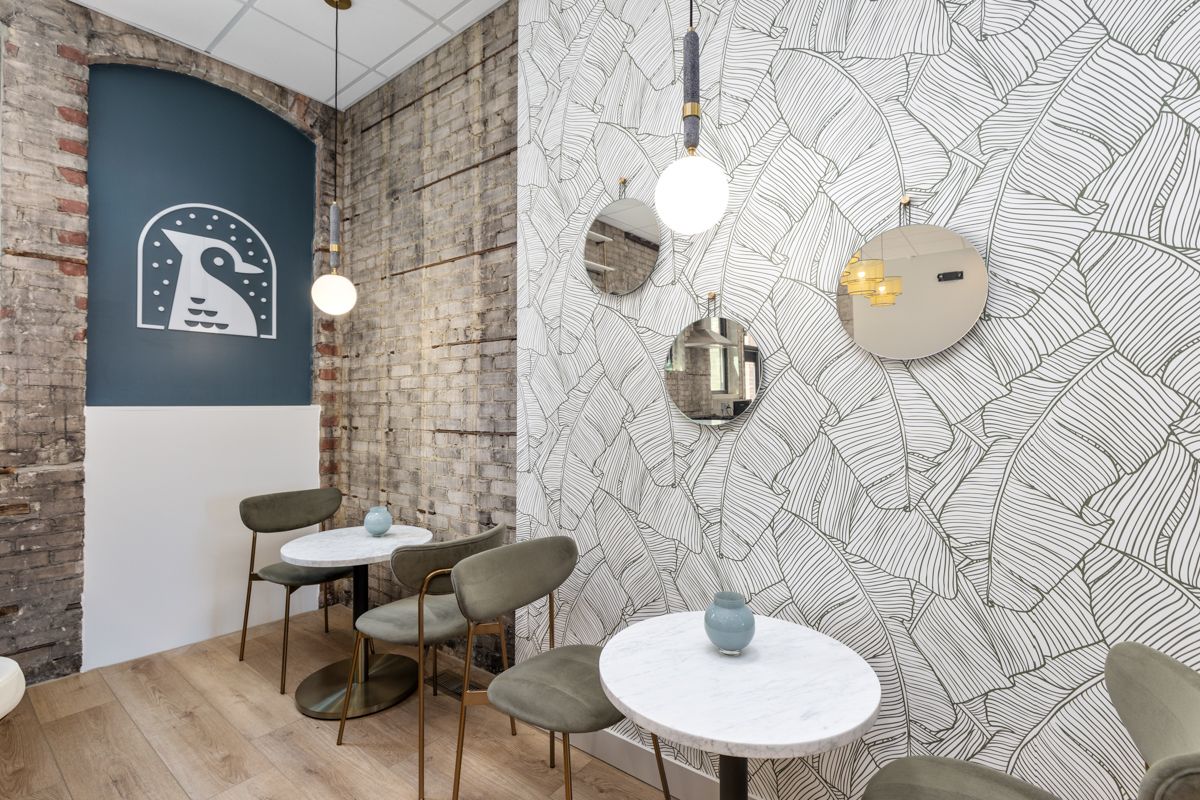 A room with tables and chairs and a clock on the wall.