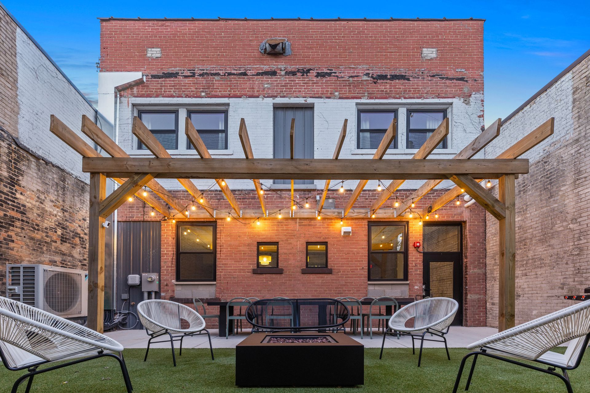 There is a fire pit in the backyard of a building.