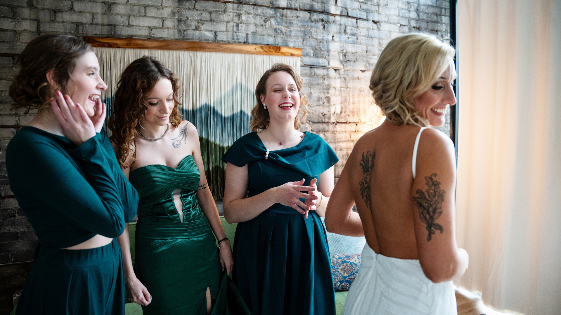 A bride and her bridesmaids are standing next to each other in a room.