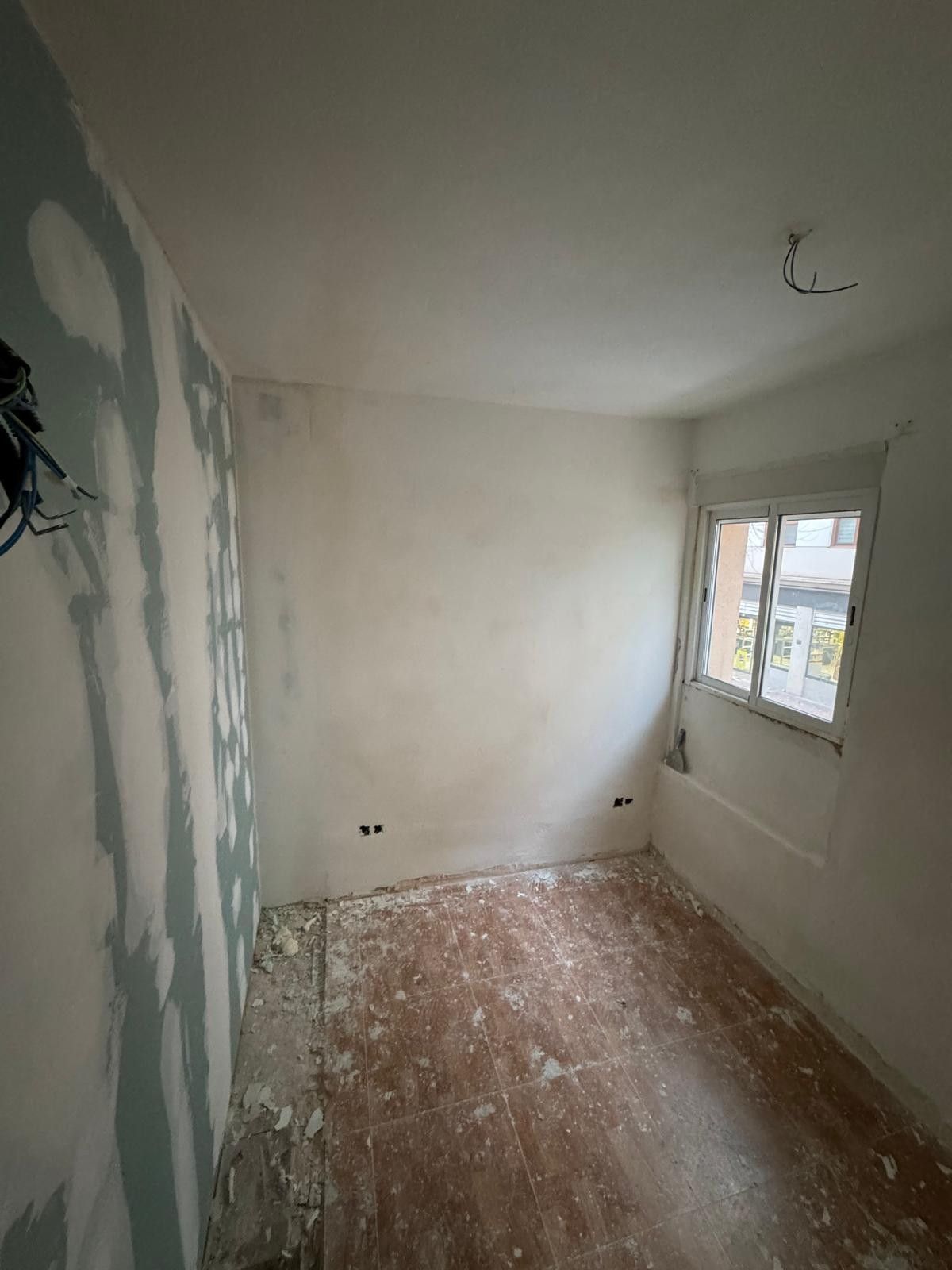 Una pequeña habitación en obras con paredes de yeso al descubierto